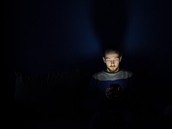man texting in dark